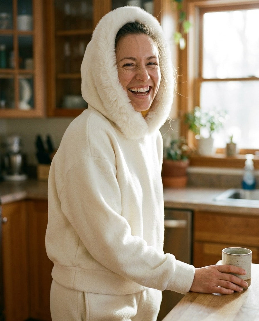 A woman laughing in The Snow Day Set for women in Snowfall, by a kitchen window