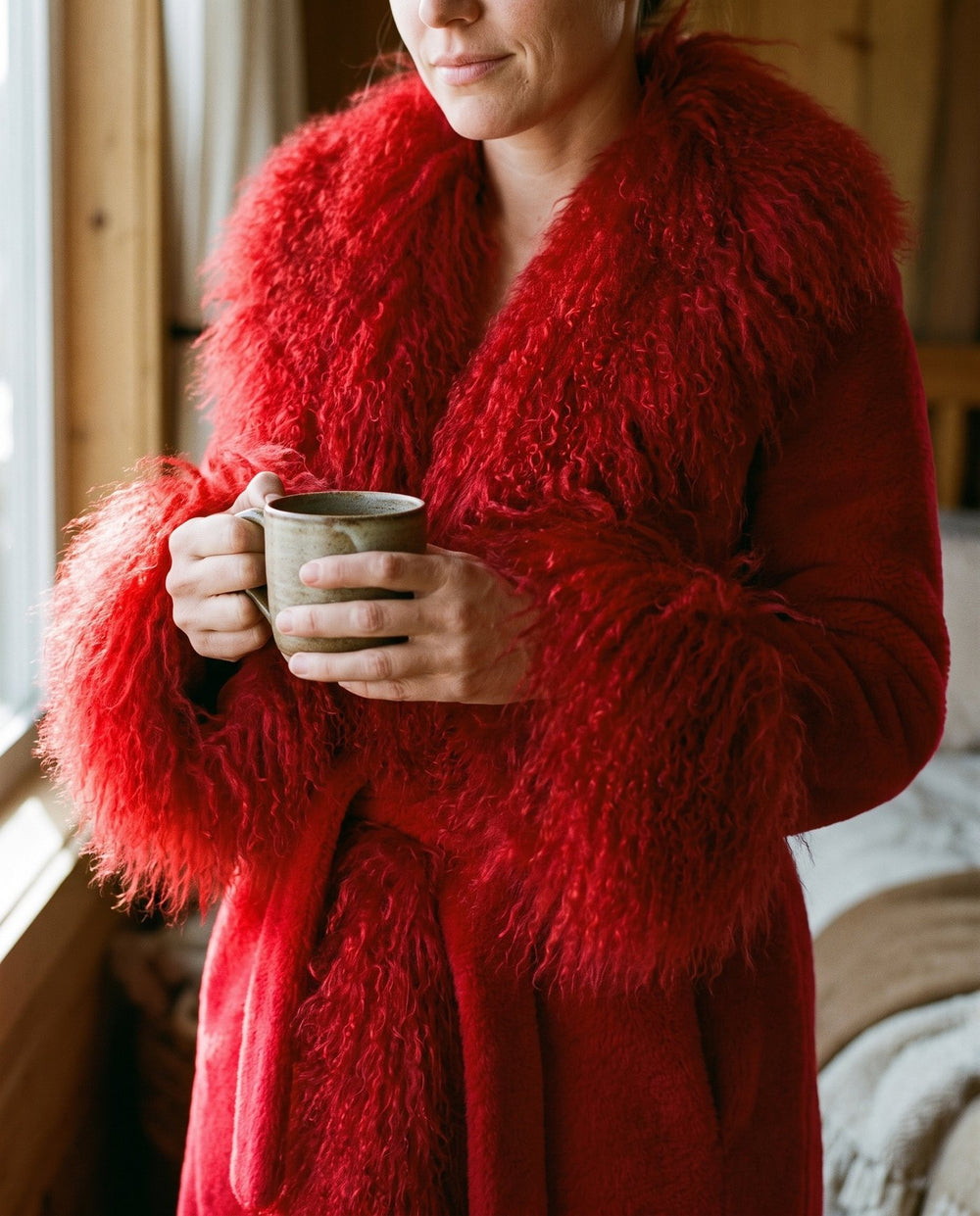 Close detail of The Ember coat, long curly red faux fur cuff against the plush sleeve, Fox & Ocean