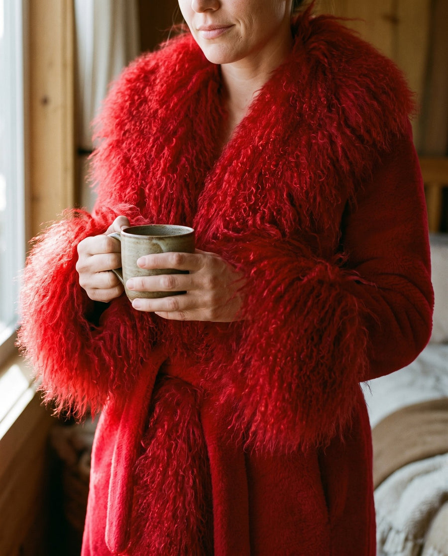 Close detail of The Ember coat, long curly red faux fur cuff against the plush sleeve, Fox & Ocean